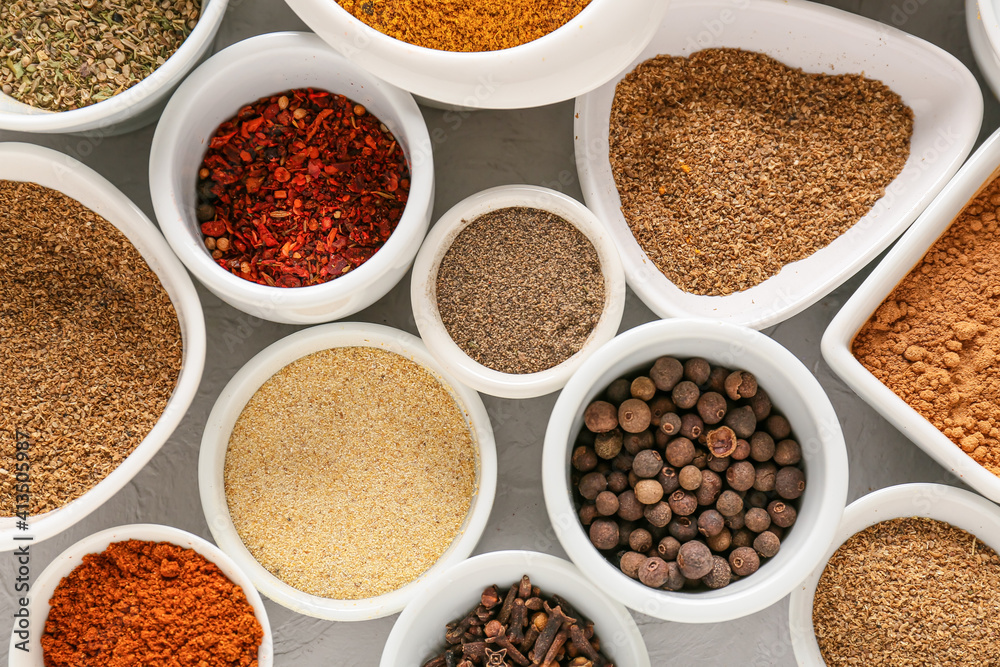 Bowls with different spices on light background, closeup