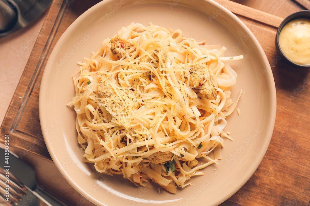 Plate with tasty noodles and chicken on table, closeup