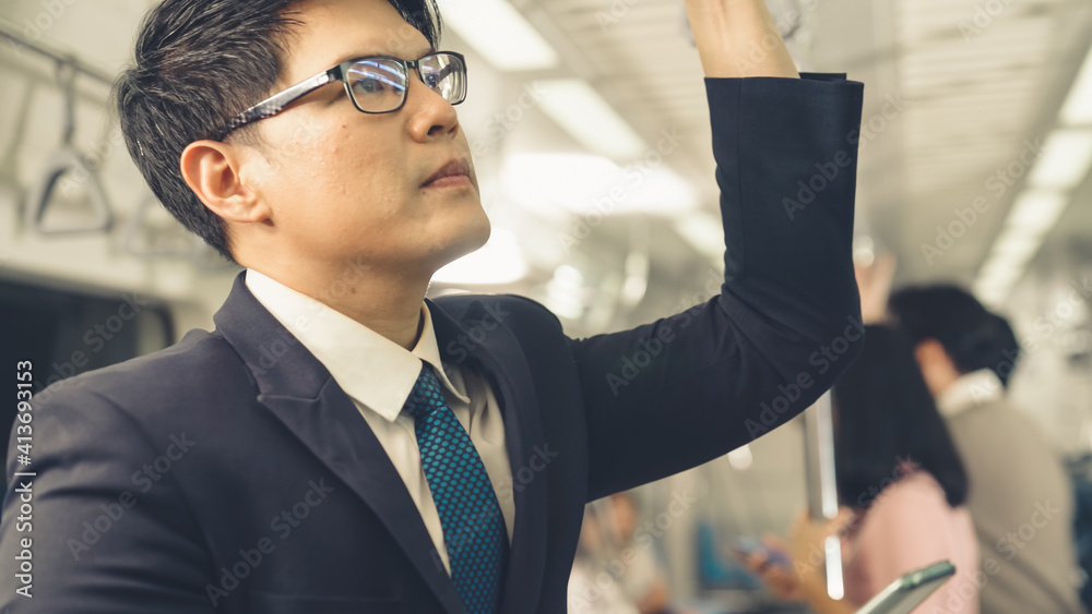 Businessman using mobile phone on public train . Urban city lifestyle commuting concept .