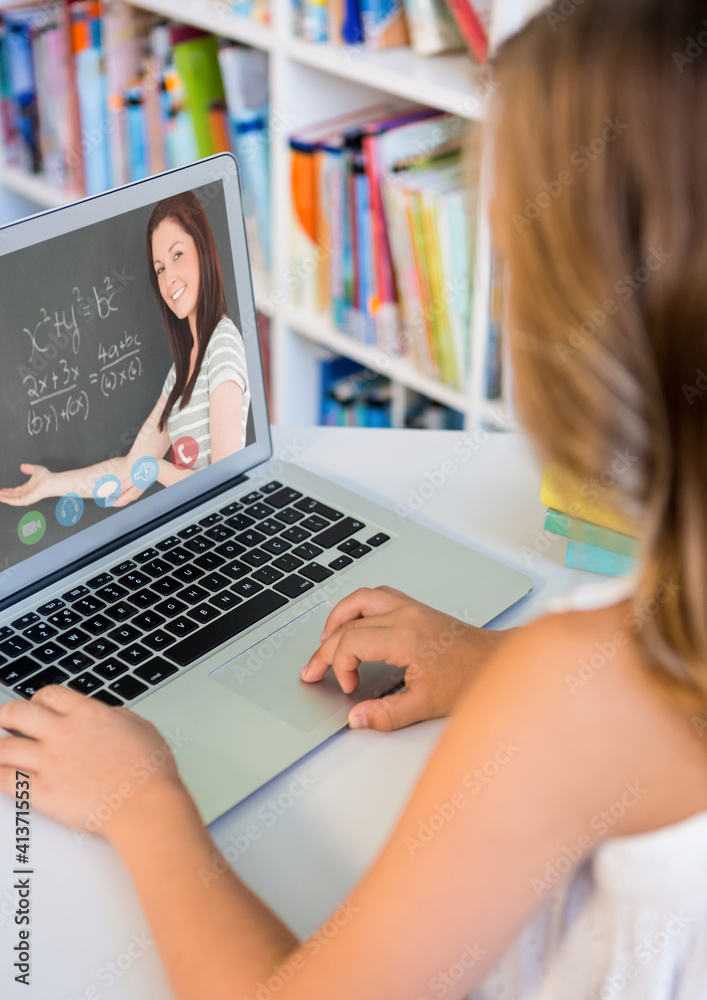 Female student having a video call with female teacher on laptop at library