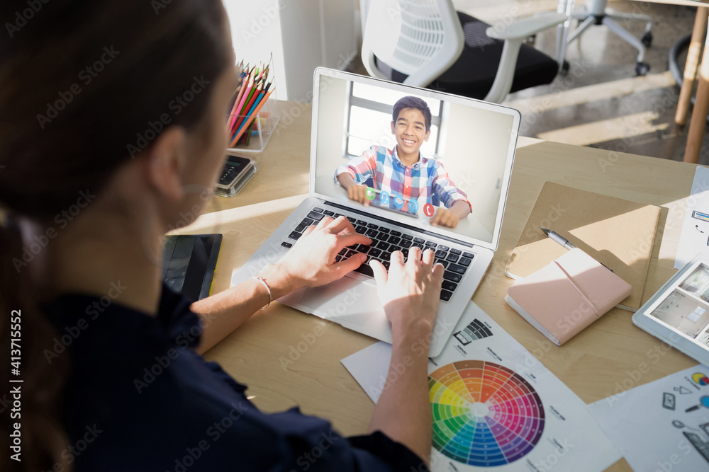 Female teacher having a video call with male student on laptop at school