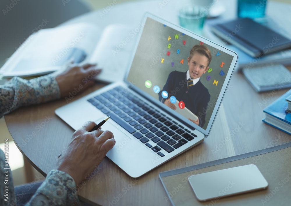 Mid section of female teacher having a video call with male student on laptop at school