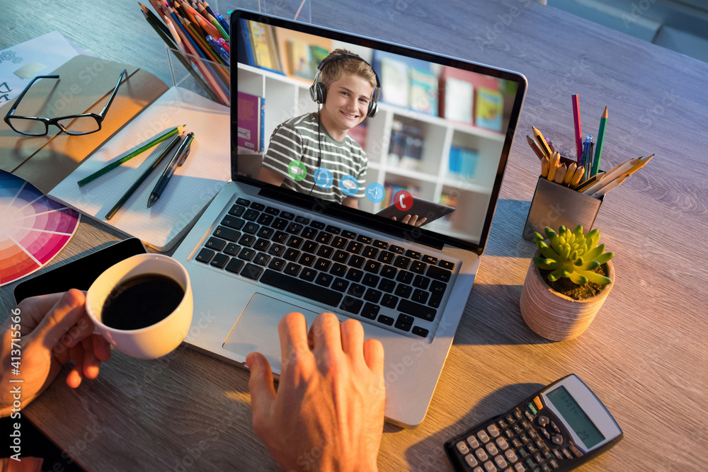 Mid section of teacher having a video call with male student on laptop at school