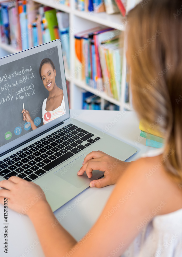 Female student having a videocall with female teacher on laptop at home