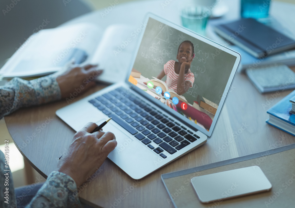 Female teacher having a videocall with female student on laptop at home