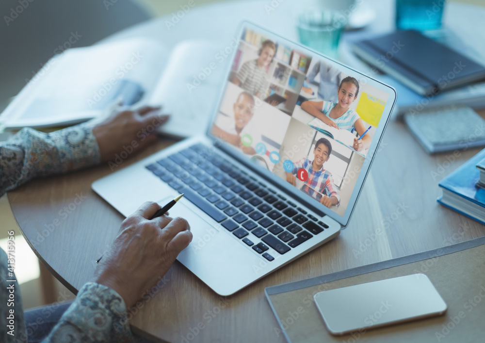 Female teacher having a video conference with multiple students on laptop at home