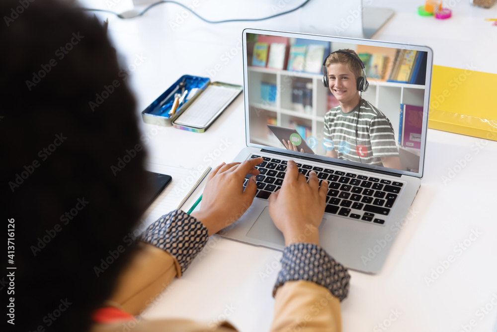 Female teacher having a video call with male student on laptop at school