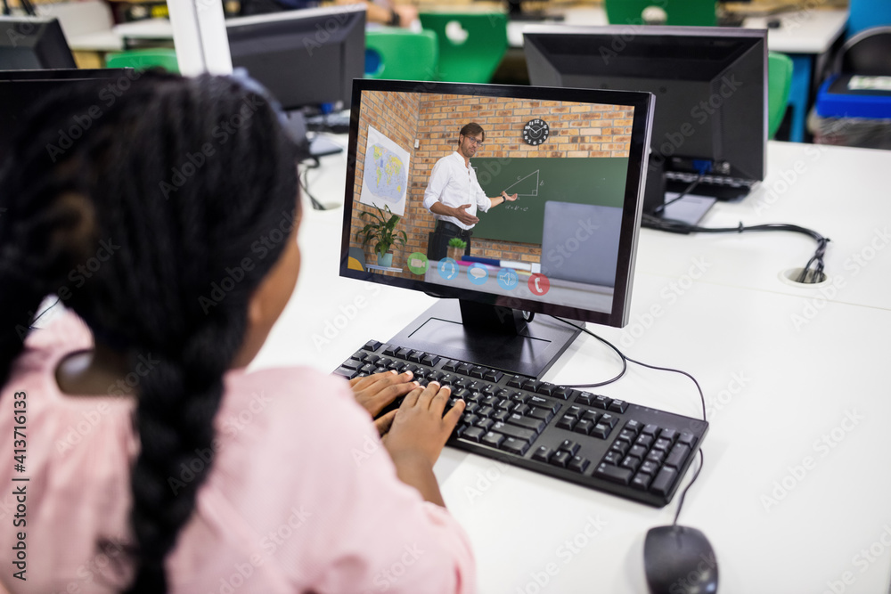 Female student having a video call with male teacher on computer at school