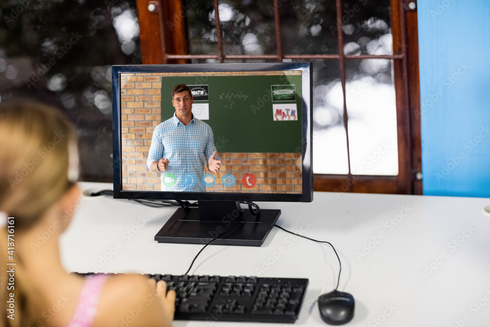 Female student having a video call with male teacher on computer at school