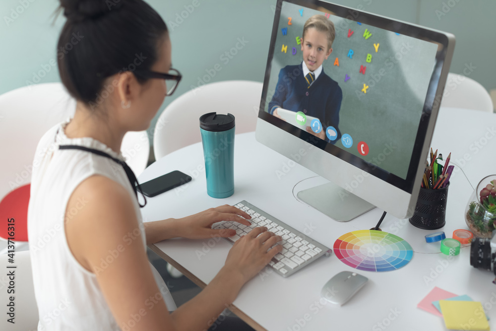 Female teacher having a video call with male student on computer at school