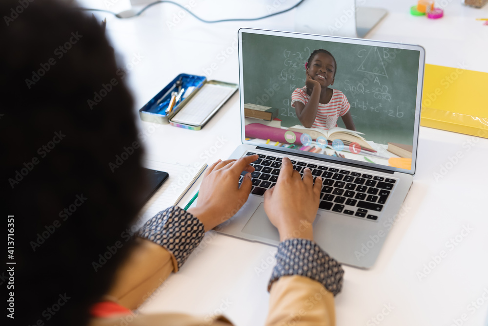 Female teacher having a video call with female student on laptop at school