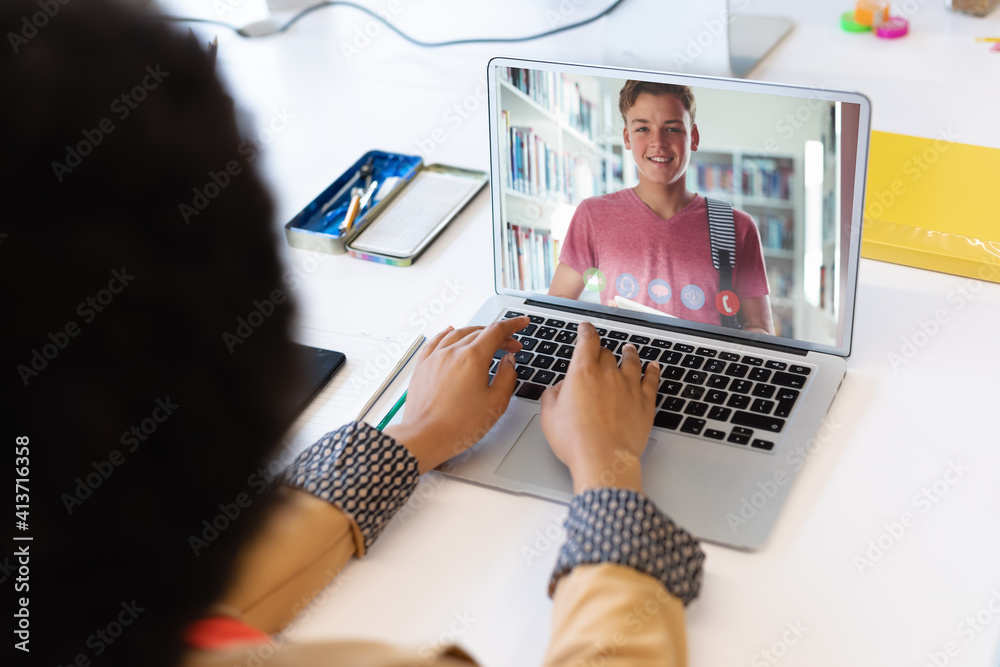 Female teacher having a video call with male student on laptop at school