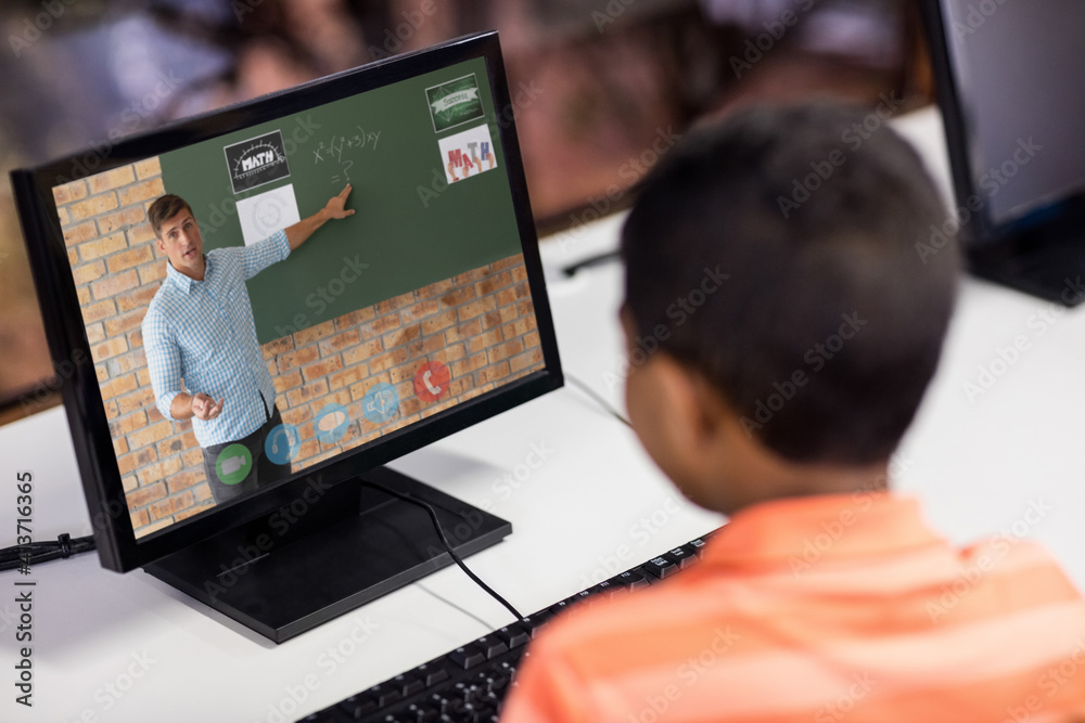 Male student having a video call with male teacher on computer at school