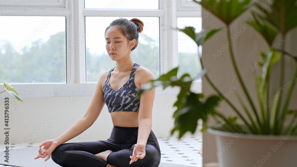 亚洲女性在家练习瑜伽和药物