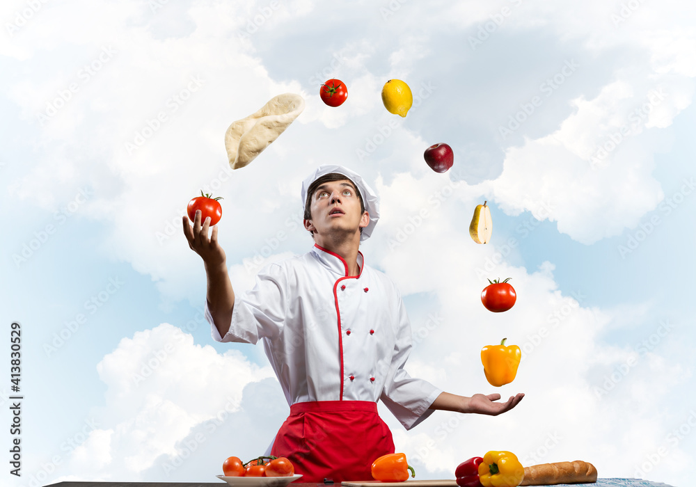 Young male chef juggles with food ingredients