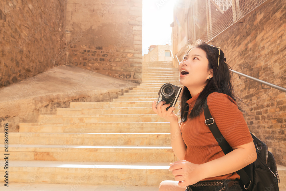 迷人的亚洲女性旅行者旅游手用相机观光车里的旧石头楼梯走廊