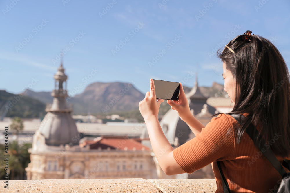 魅力四射的亚洲女性旅行者旅游手用相机观光老房子建筑设计师