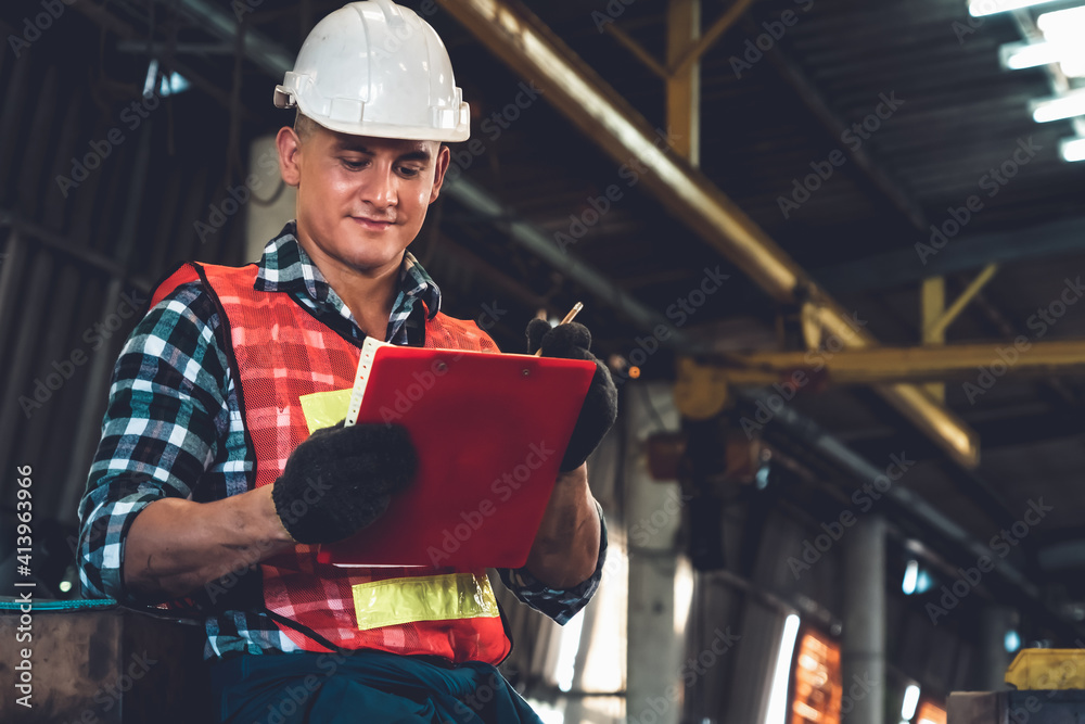 Manufacturing worker working with clipboard to do job procedure checklist . Factory production line 