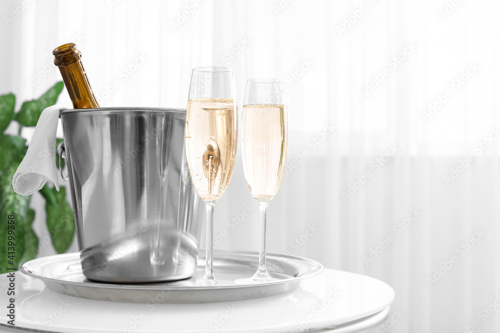 Bottle and glasses of champagne on table in hotel honeymoon room