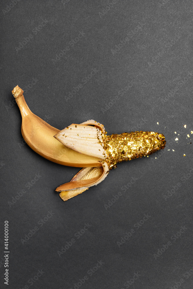 Golden banana on dark background