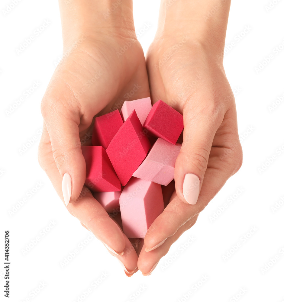 Hands with makeup sponges on white background