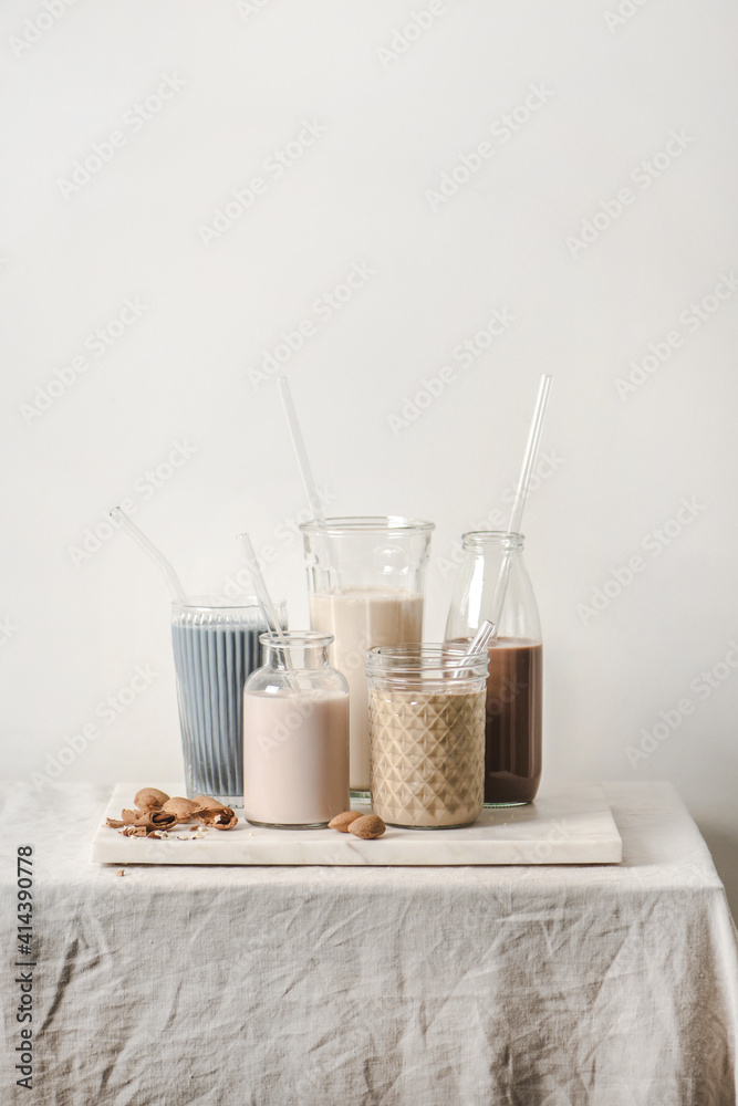 Dairy-free milk assortment with different flavours. Almond milk with blue matcha, berries, coffee, c