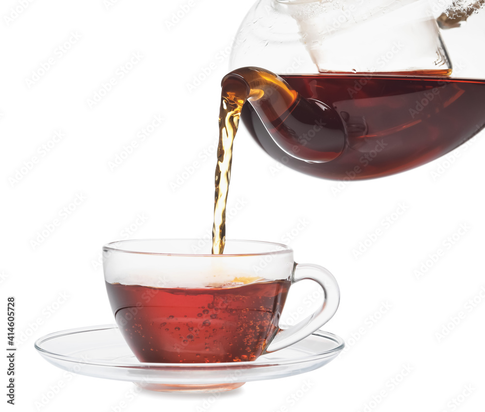 Pouring of hot tea from teapot into cup on white background