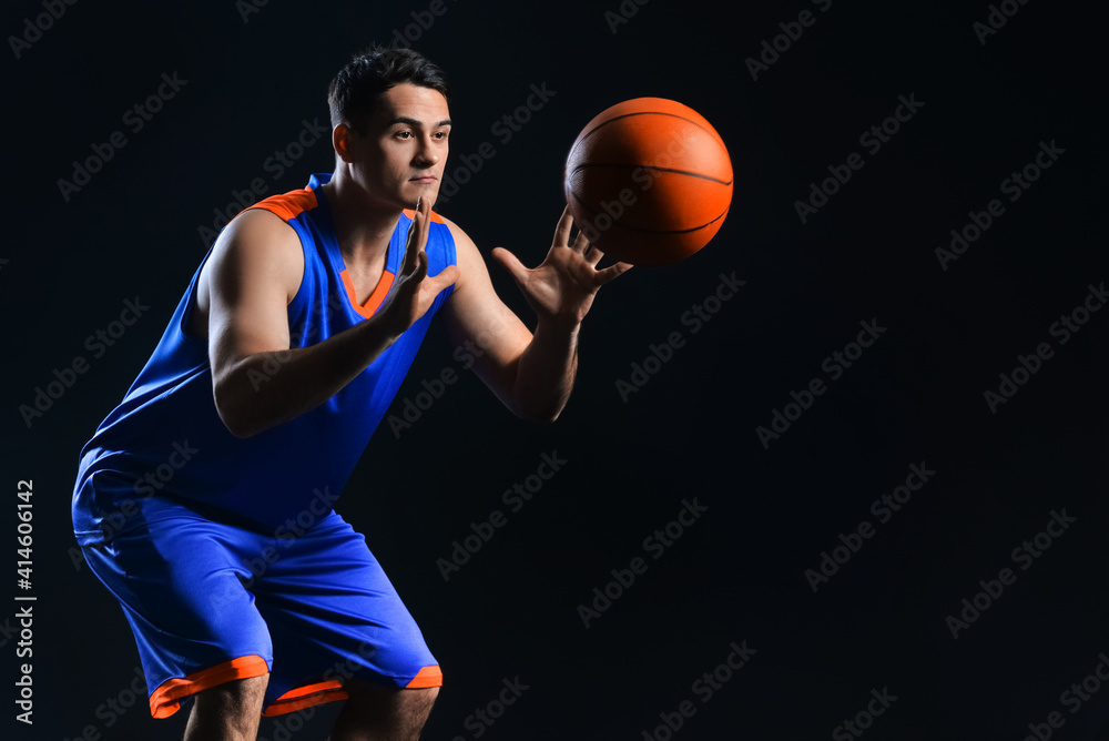 Male basketball player on dark background