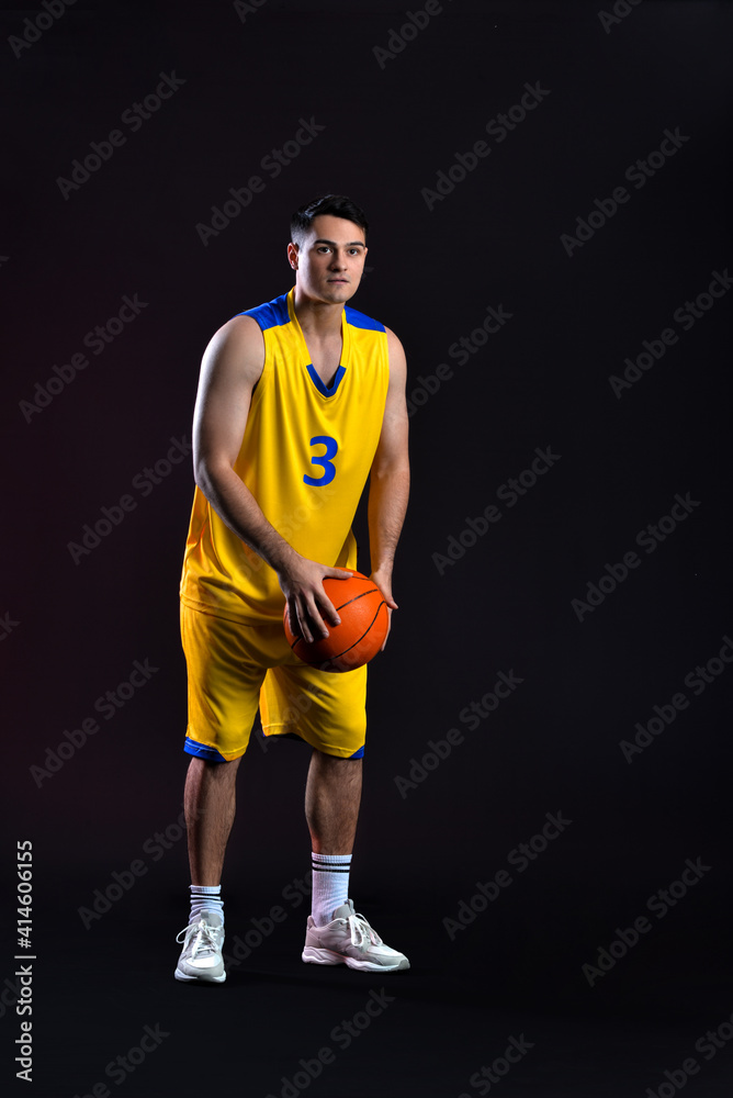 Male basketball player on dark background