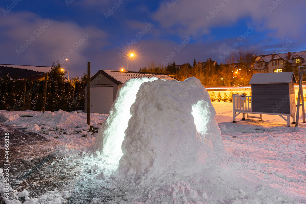 美丽的冬季花园，夜晚有雪屋。波兰