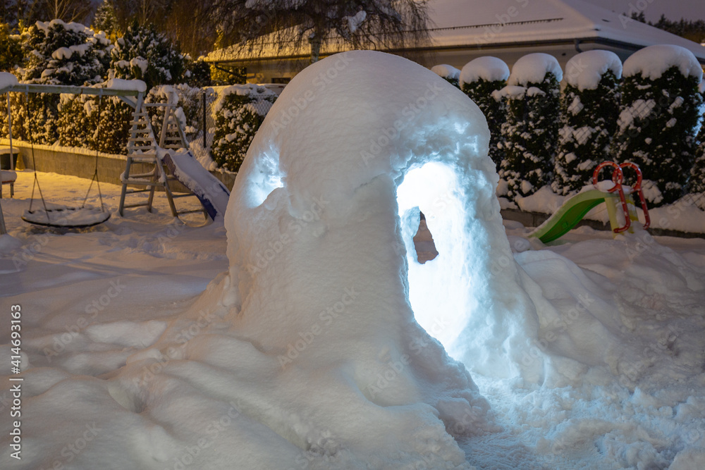 Beautiful winter garden with snow igloo at night. Poland