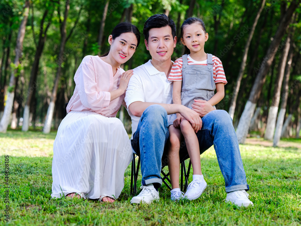 Happy family of three playing in the park