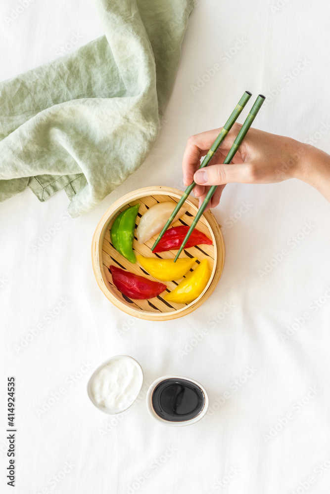 Colored dumplings in wooden steamer, top view