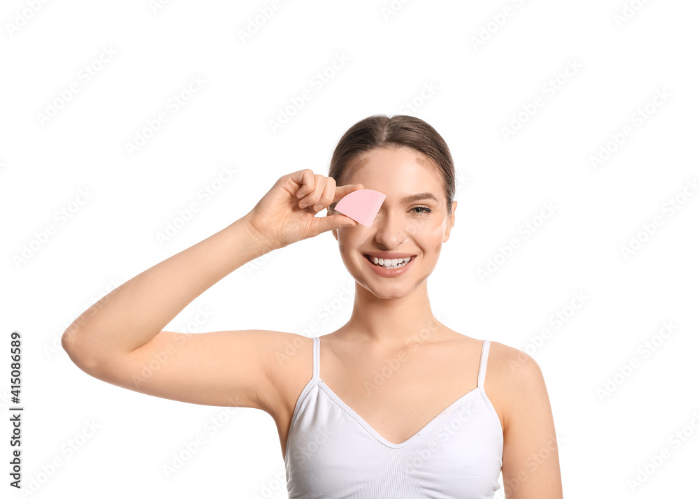 Beautiful young woman applying contouring makeup against white background