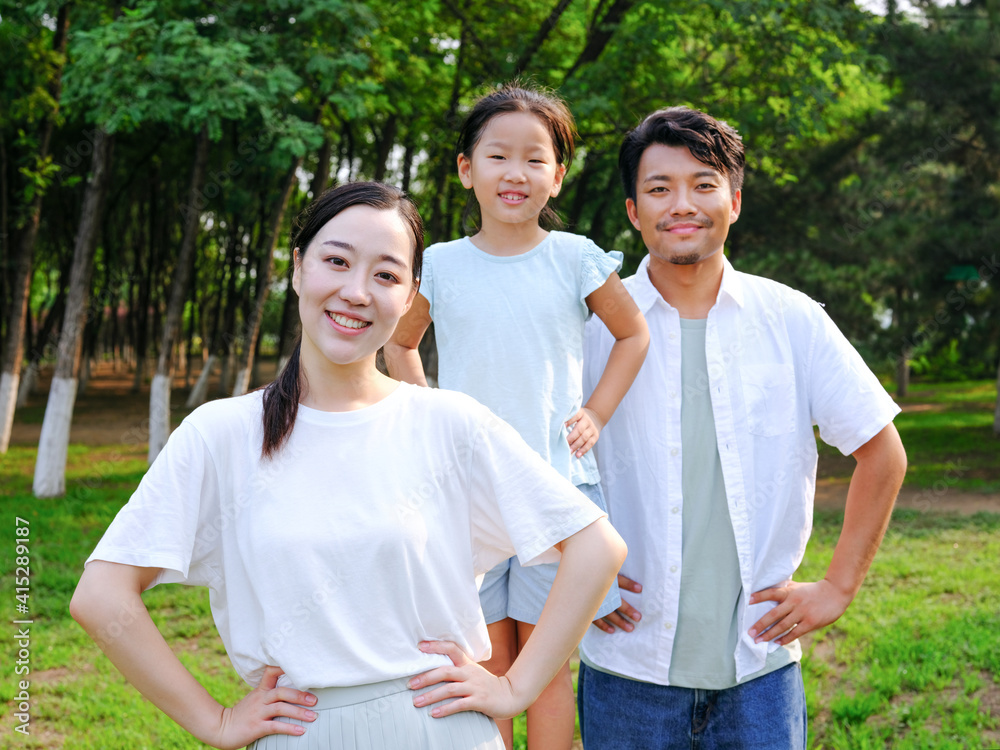 Happy family of three playing in the park