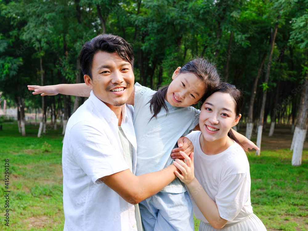 Happy family of three playing in the park