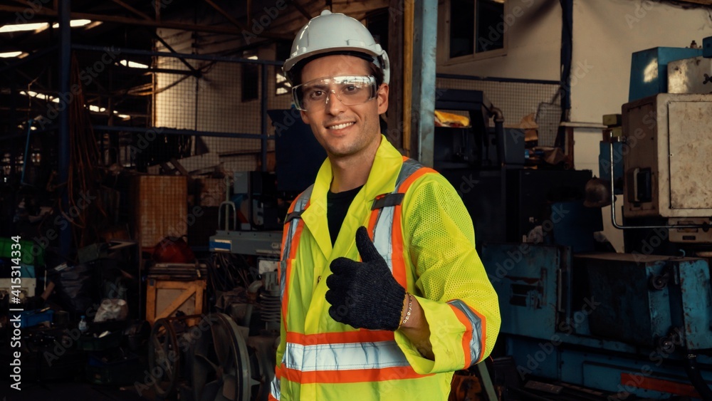 Young skillful factory worker or engineer close up portrait in factory . Industry and engineering co