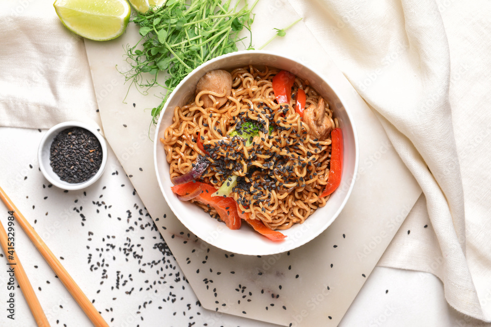 Bowl with tasty noodles and meat on light background