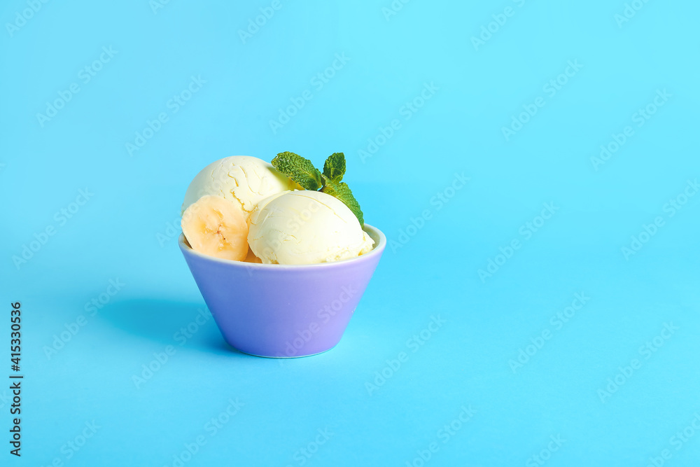 Tasty banana ice-cream in bowl on color background