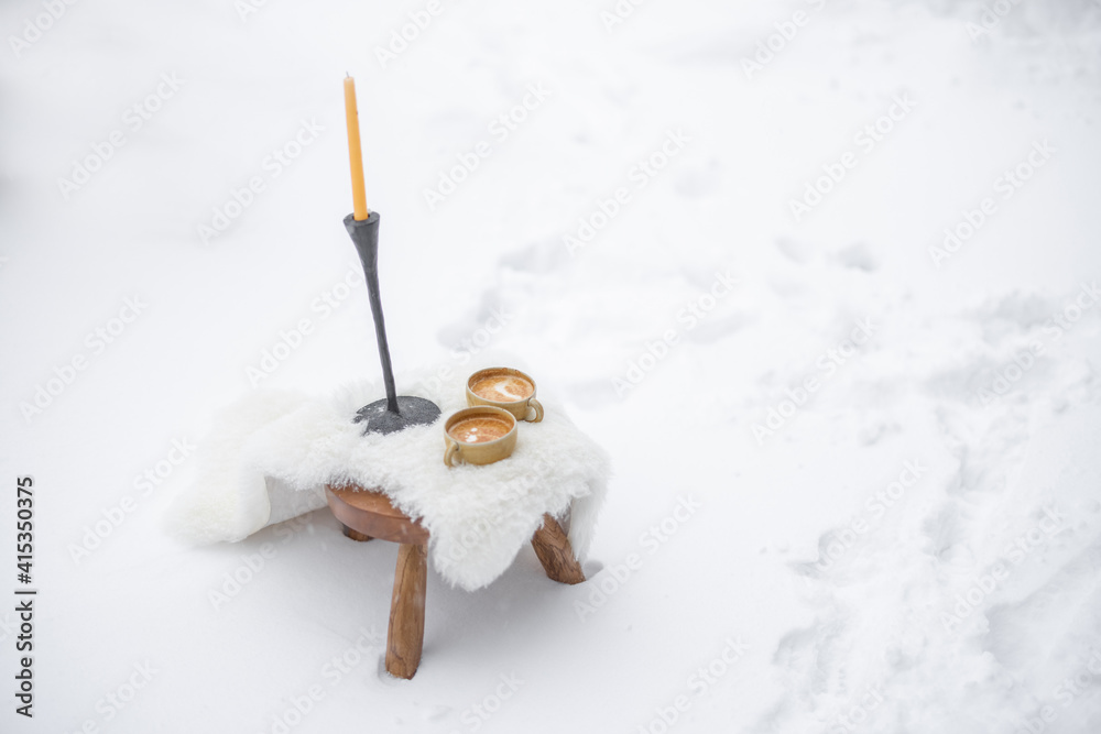 Romantic coffee break serve on white sheep leather on the snow. High quality photo