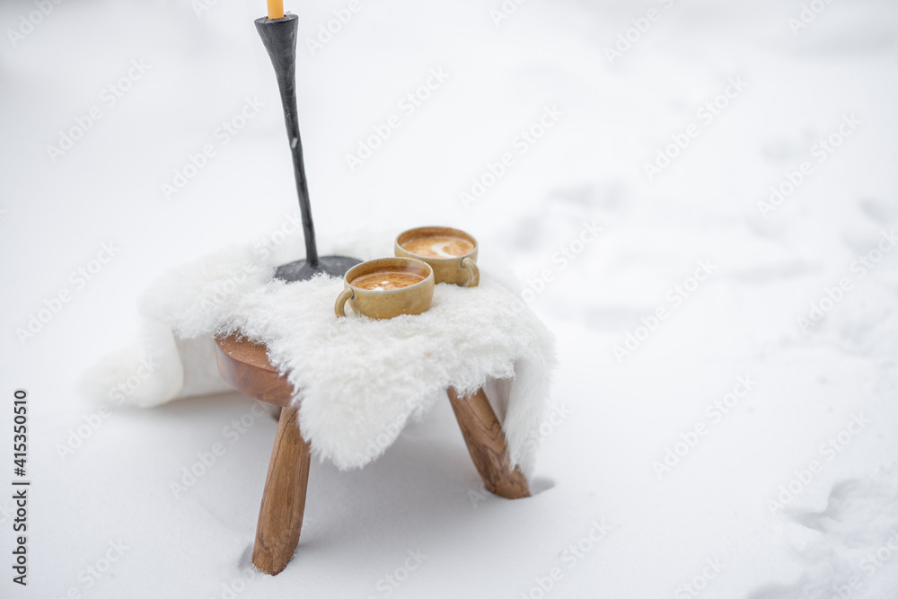 Romantic coffee break serve on white sheep leather on the snow. High quality photo