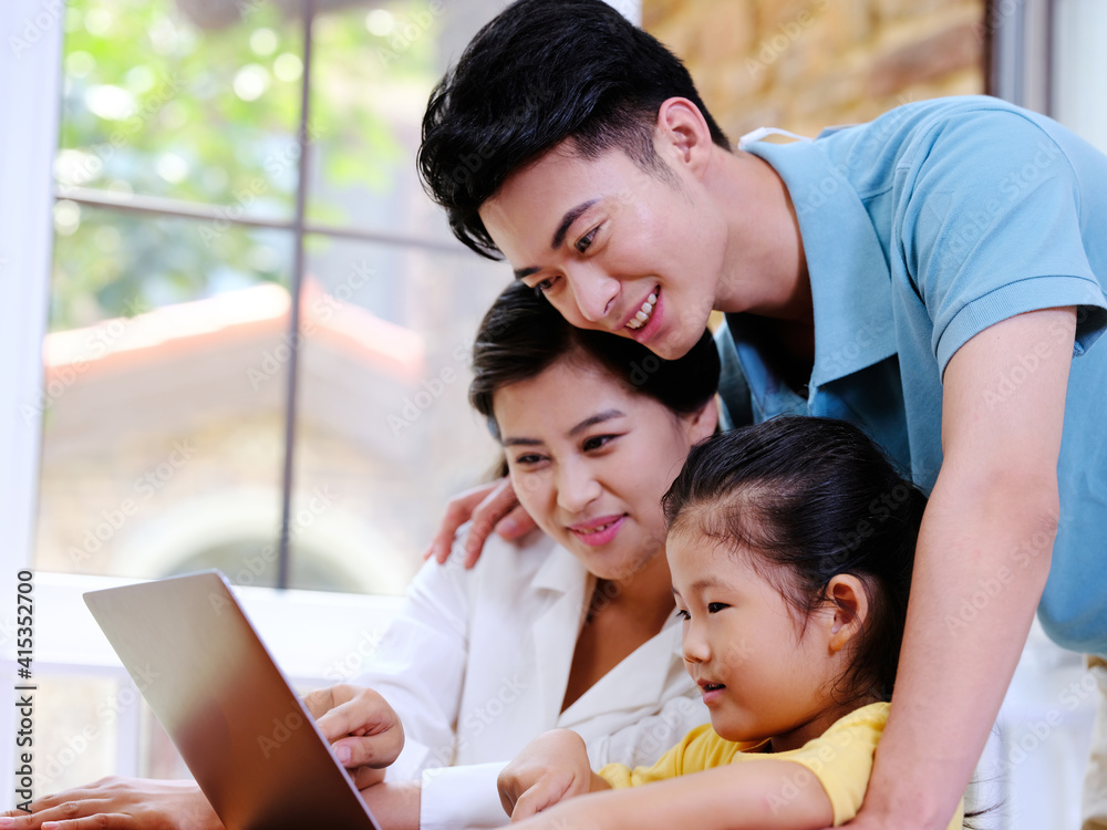 Happy family of three using laptop