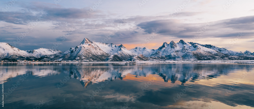 Breathtaking birds eye view of high mountain rocky peaks covered with white snow reflected in Norwa