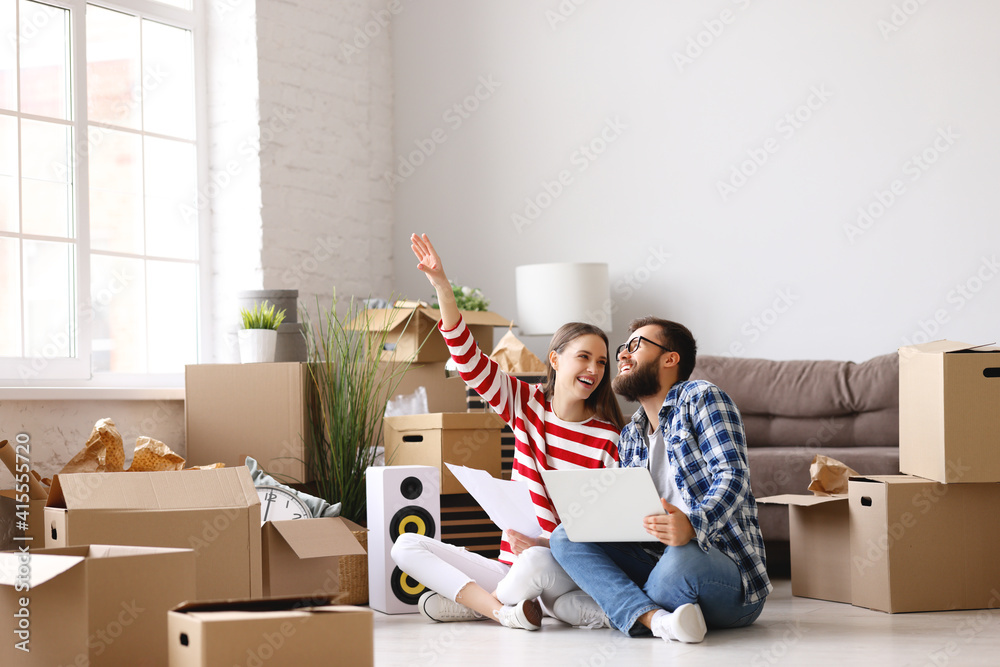 Content couple with laptop planning design of new apartment