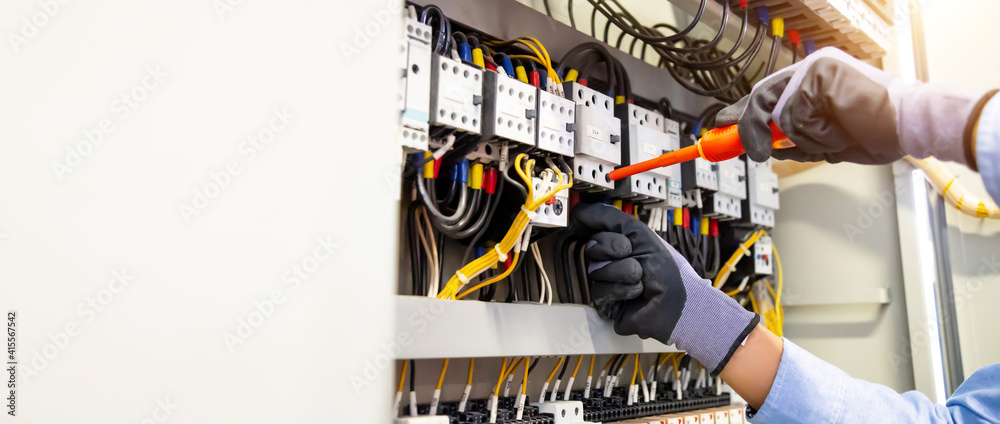 Electricians work to connect electric wires in the system, switchboard, electrical system in Control