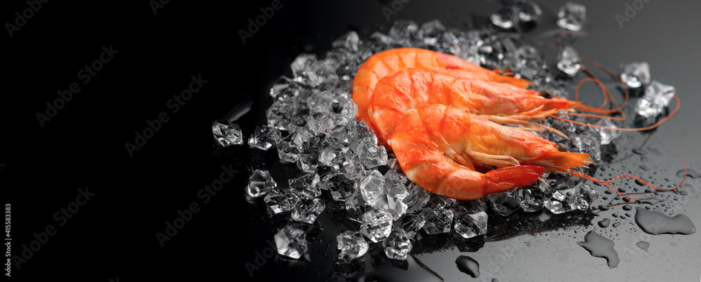 Shrimps. Fresh Prawns on a Black Background. Seafood on crashed ice, dark background, preparing heal