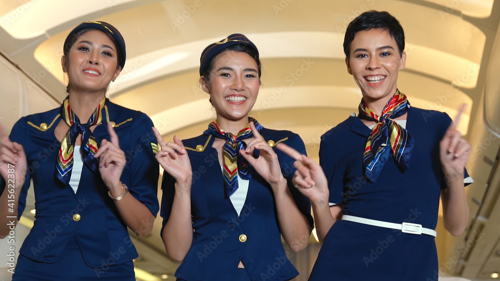 Cabin crew dancing with joy in airplane . Airline transportation and tourism concept.