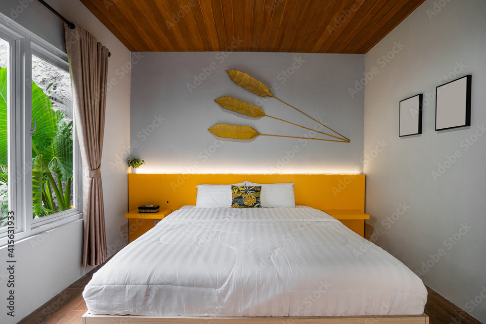 White pillows on wooden bed in minimal bedroom interior with window