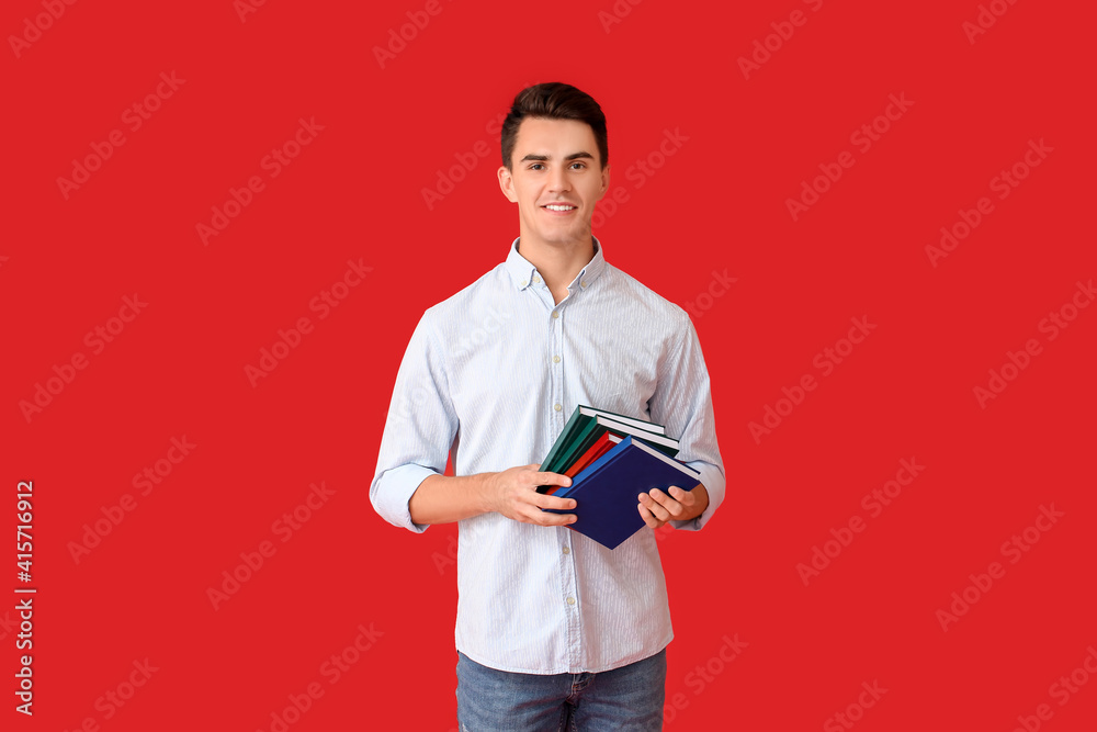 Young man with books on color background