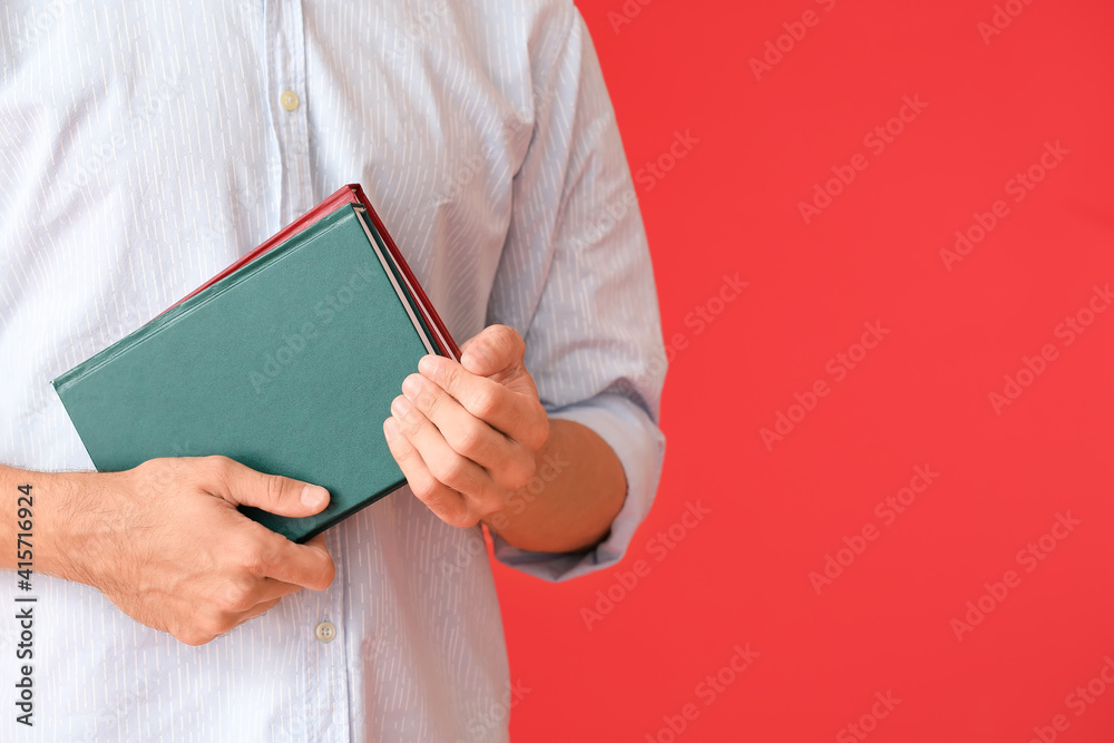 Young man with books on color background, closeup